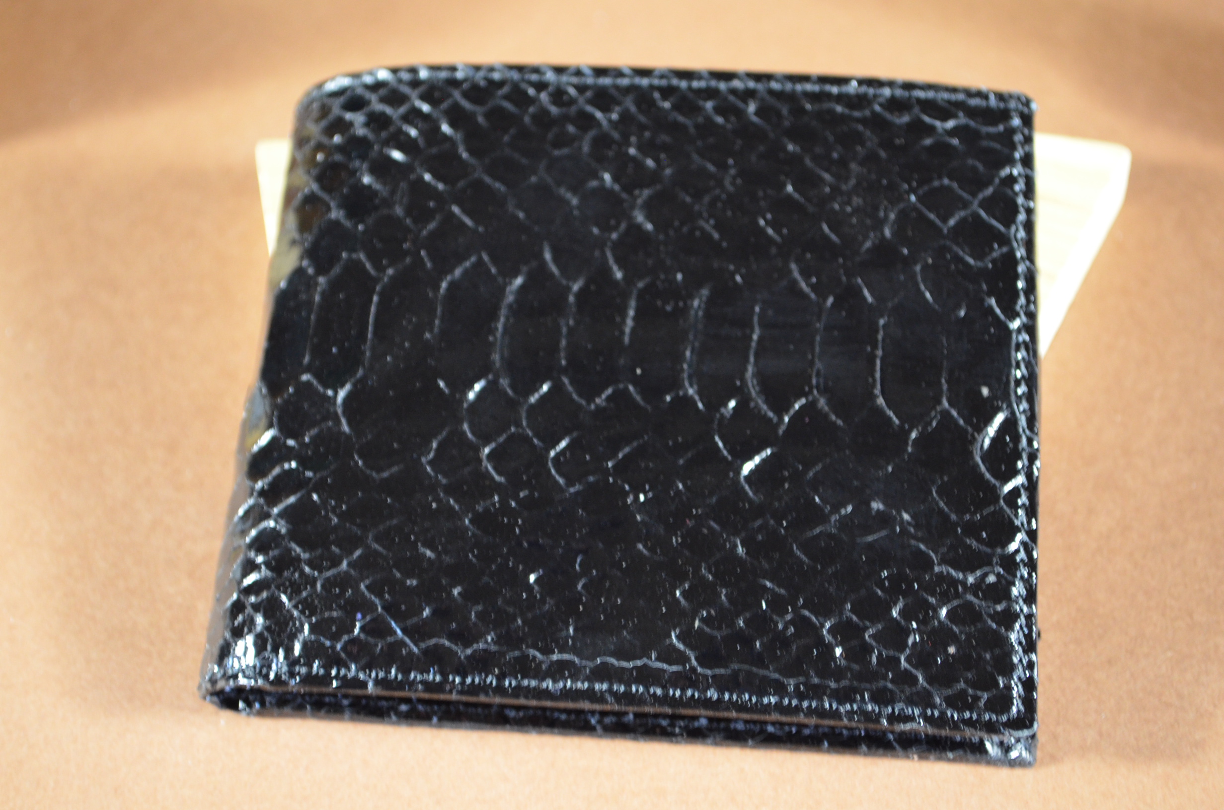 ROMA - PYTHON 5 BLACK es una de nuestras carteras de cuero artesanales hechas a mano en piel de ubrique hechas a mano, fabricada con vientre de pitón brillante y cuero vacuno / textil en el interior. De color negro.